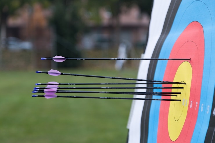 Photo close-up of archery target with arrows on it.