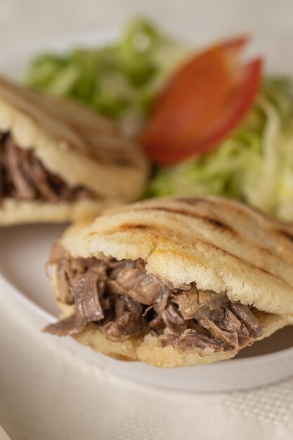 Close up Arepas typical Venezuelan food made with maize and filled with shredded meat and salad