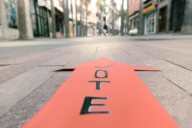 Close-up of arrow sign on building in city