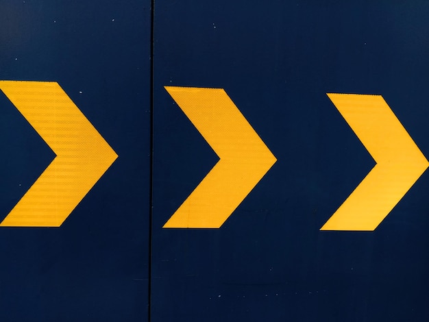 Photo close-up of arrow sign on road