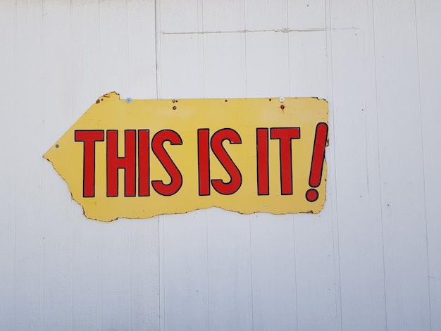 Close-up of arrow sign on wall