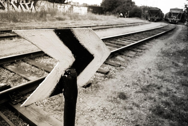 Close-up of arrow symbol against railroad track