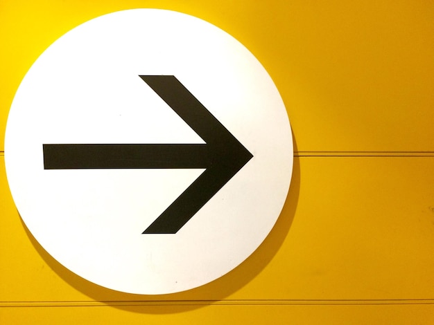 Close-up of arrow symbol against wall