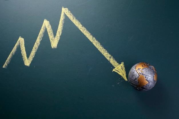 Photo close-up of arrow symbol with globe on table