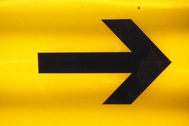 Photo close-up of arrow symbol on yellow board