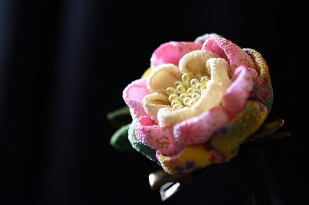 Close-up of artificial flower against black background