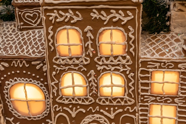 Close up of artificial ginger bread house wit lights on christmas and new year holidays interior dec...