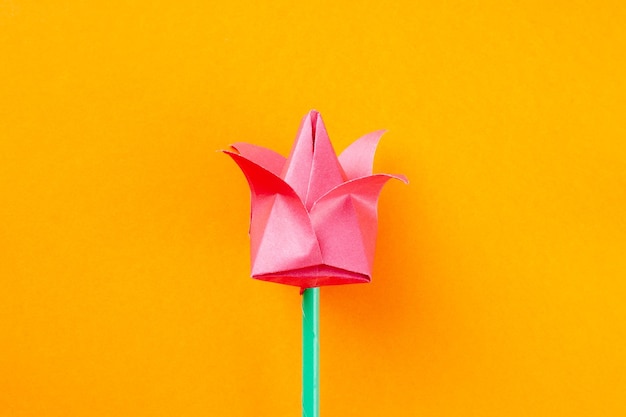 Foto close-up di un fiore rosa artificiale su sfondo giallo