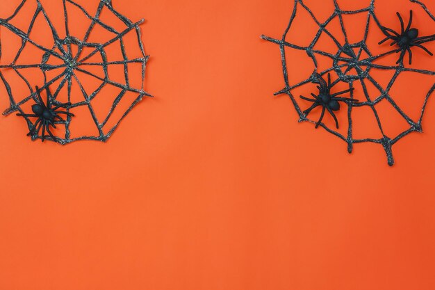 Close-up of artificial spiders on orange background