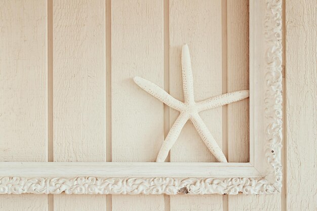 Foto close-up di una stella marina artificiale su una cornice di legno