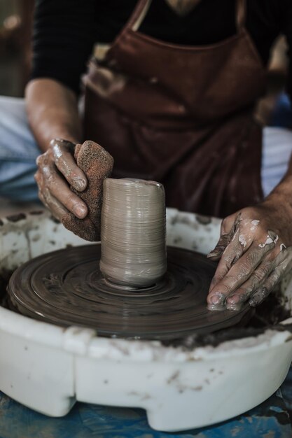 Photo close-up of artist making pot at workshop