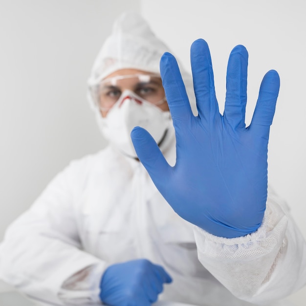 Foto close-up arts die een gezichtsmasker en chirurgische handschoenen draagt