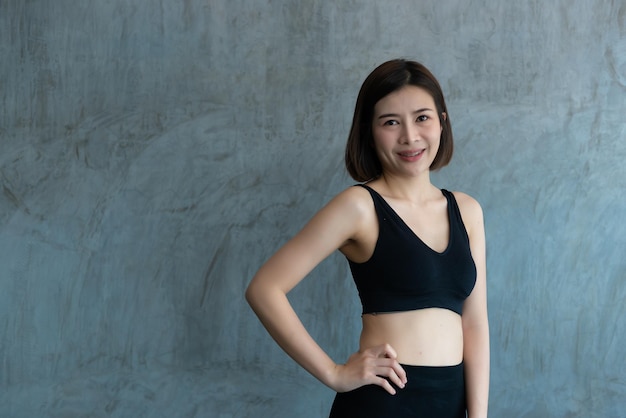 Крупным планом азиатская красивая спортивная девушка на стене тренажерного зала Таиланд любит здоровье Концепция тренировки стройной женщины