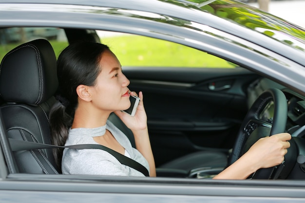 Close-up asian beautiful woman calling mobile phone while driving car