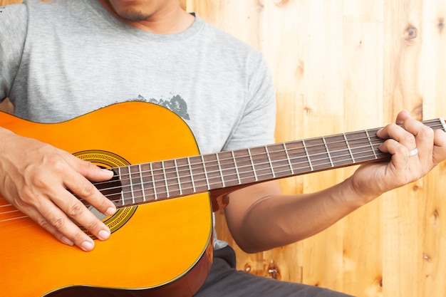 Close up asian man playing guitar