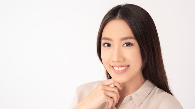 Close up of Asian woman with beautiful teeth on white wall