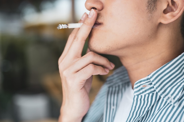 Photo close-up of asian young man smoking a cigarette