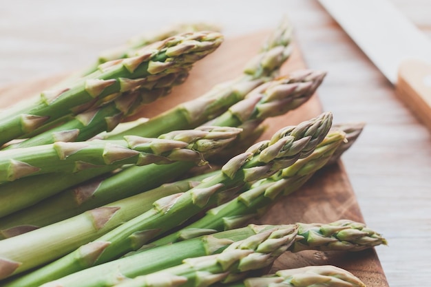 Foto prossimo piano di asparagi su una tavola da taglio sopra il tavolo