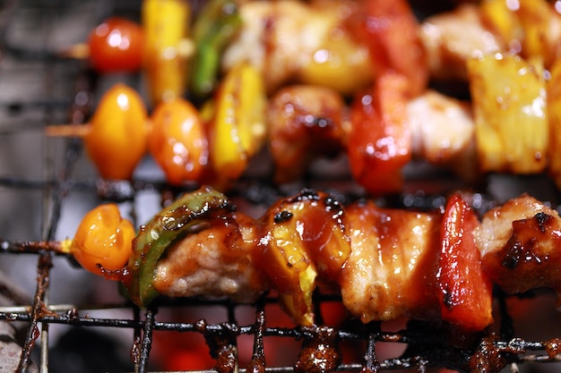 Close up assorted delicious grilled meat with vegetables over the coals on a barbecue