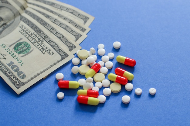 Close-up Assorted pharmaceutical medicine pills, tablets and dollars.