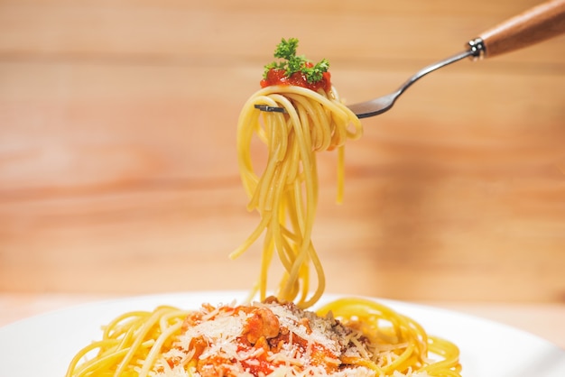 Close-up of asta spaghetti with tomato sauce, olives and garnish. Italian food.