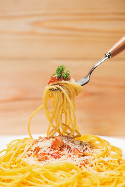 Close-up of asta spaghetti with tomato sauce, olives and garnish. Italian food.