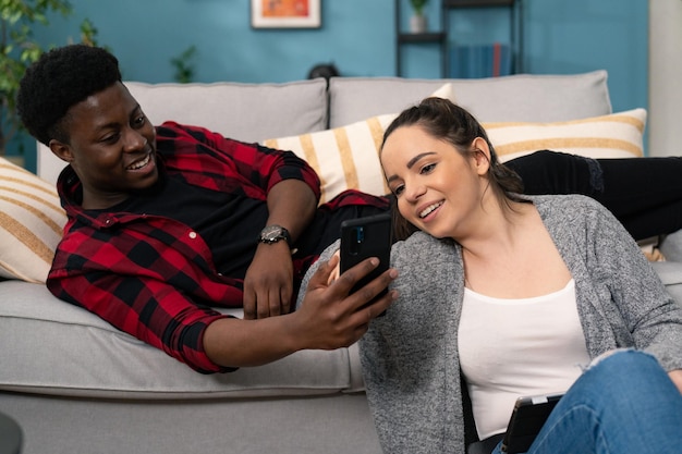 Close up of the attractive smiled african american man showing something on the phone