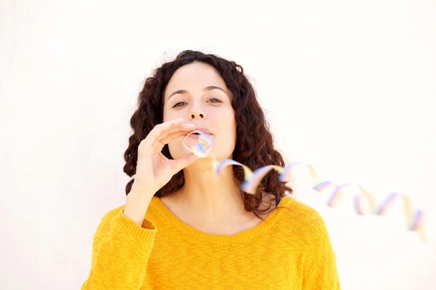 Close up attractive young woman blowing confetti