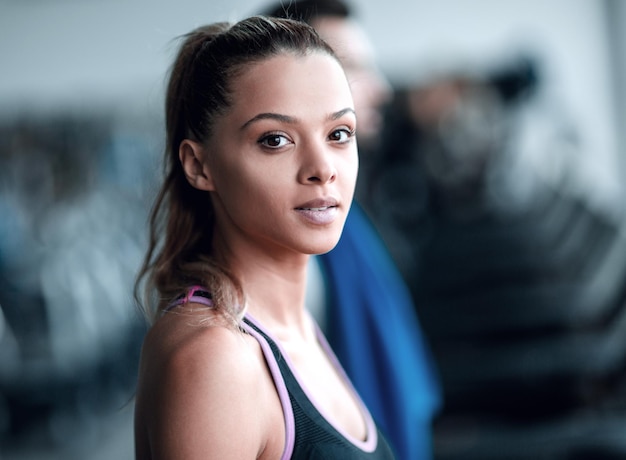 Foto chiuda sulla giovane donna attraente in palestra