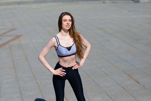 A close up of attractive young woman running, doing fitness outdoors