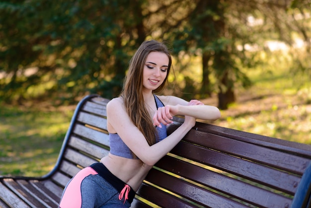 A close up of attractive young woman sitting on a bench
