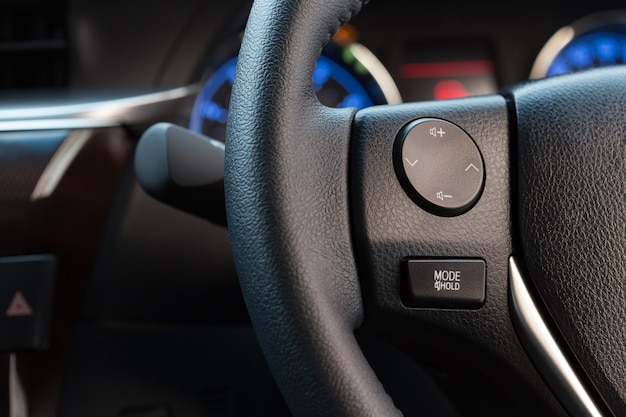 Close up audio control button on car steering wheel