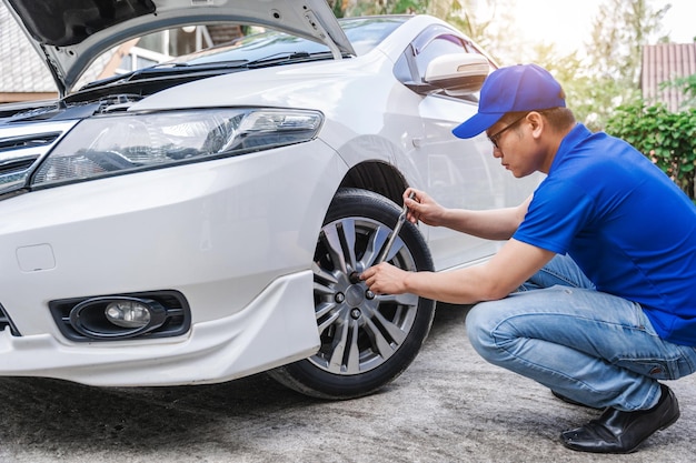 Close up auto mechanic man checking car tire Car service Hands replace tires on wheels Tire installation concept