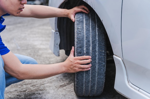 Close up auto mechanic man checking car tire car service hands\
replace tires on wheels tire installation concept