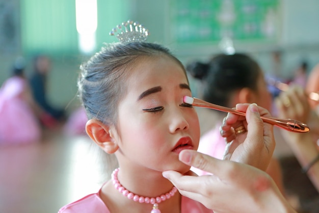 Close-up Aziatisch meisje met make-up door haar moeder.