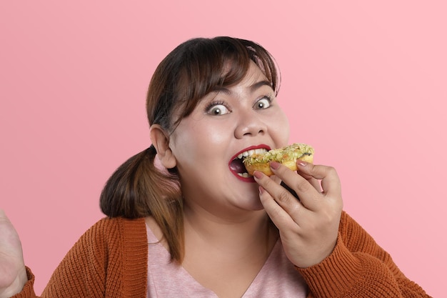 Close-up Aziatische jonge vrouw eten en gelukkig genieten tijdens het eten van donut snack