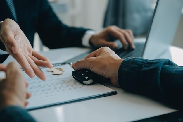 Close-up Aziatische mannelijke mensen auto verkoper of verkoopmanager biedt een auto aan te verkopen en legt de voorwaarden voor het ondertekenen van een auto contract en verzekering uit en leest ze voor