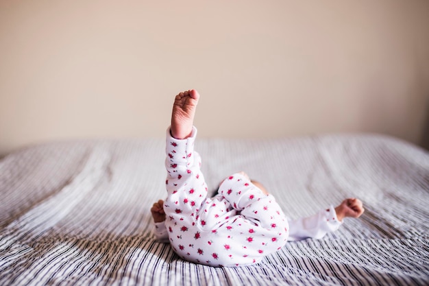 Photo close-up of baby boy on bed at home