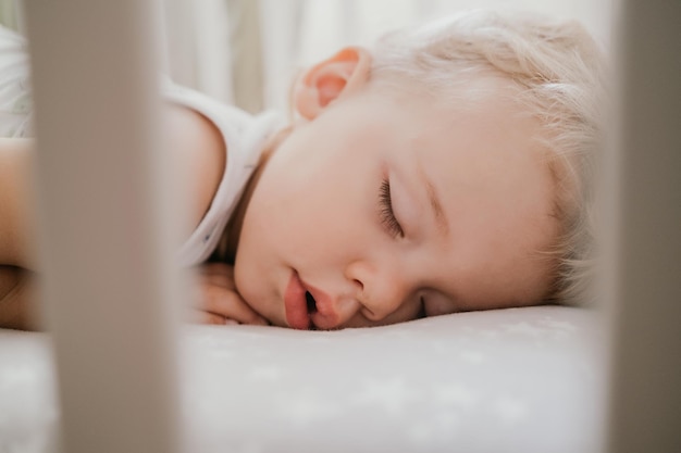 Close-up of baby boy sleeping on bed at home