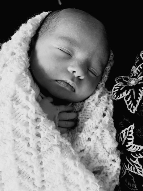 Photo close-up of baby boy sleeping on bed at home