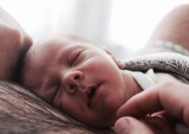 Close-up of baby boy sleeping on father chest