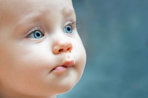 Photo close up of a baby face with blue eyes