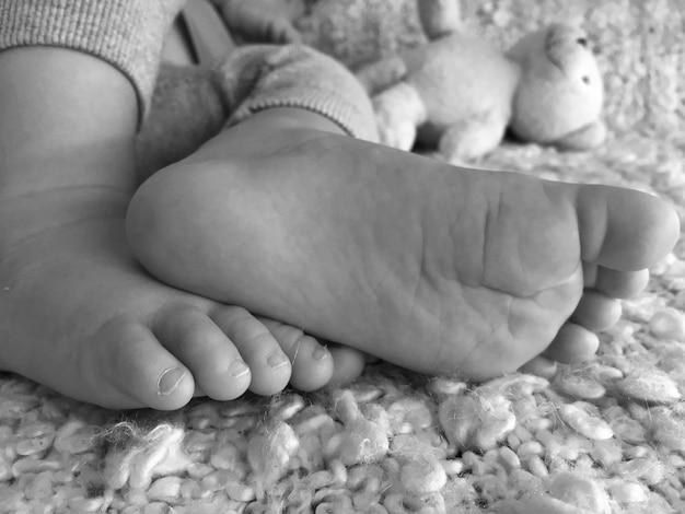 Photo close-up of baby feet on bed