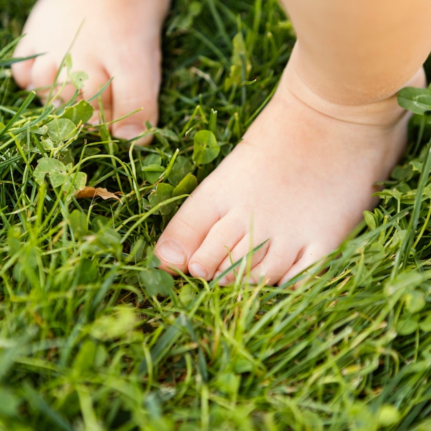 Chiudere i piedi del bambino in erba