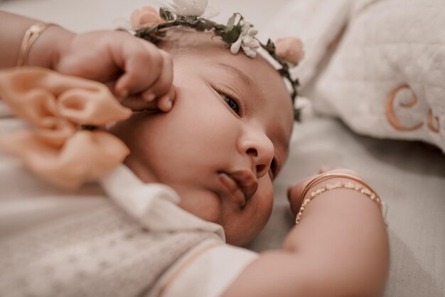 Photo close-up of baby girl lying on bed