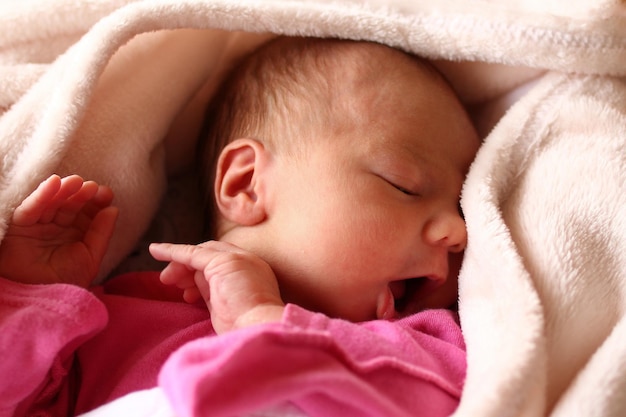 Close-up of baby girl sleeping on bed