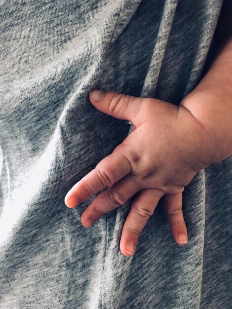 Foto prossimo piano della mano del bambino sul tessuto