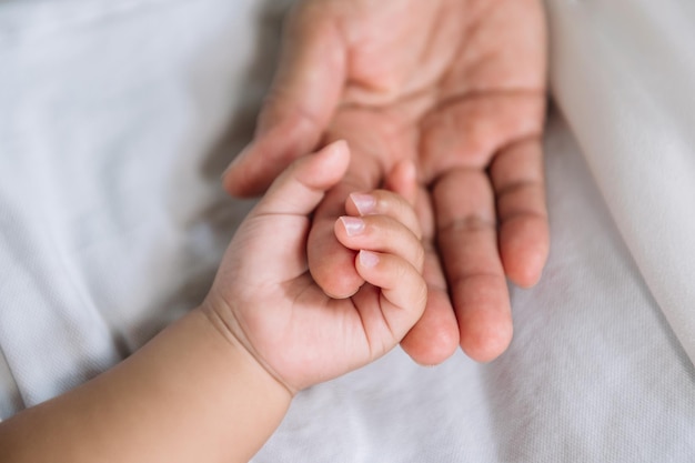 Close up baby hand on mother's handxA