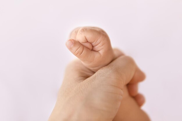 Photo close-up of baby hand over white background