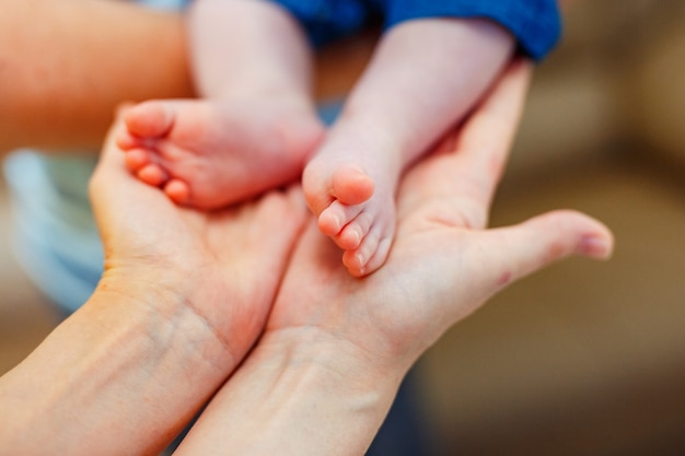 Close up of baby's feet in mother's hands